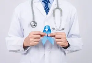 doctor holding light blue ribbon.