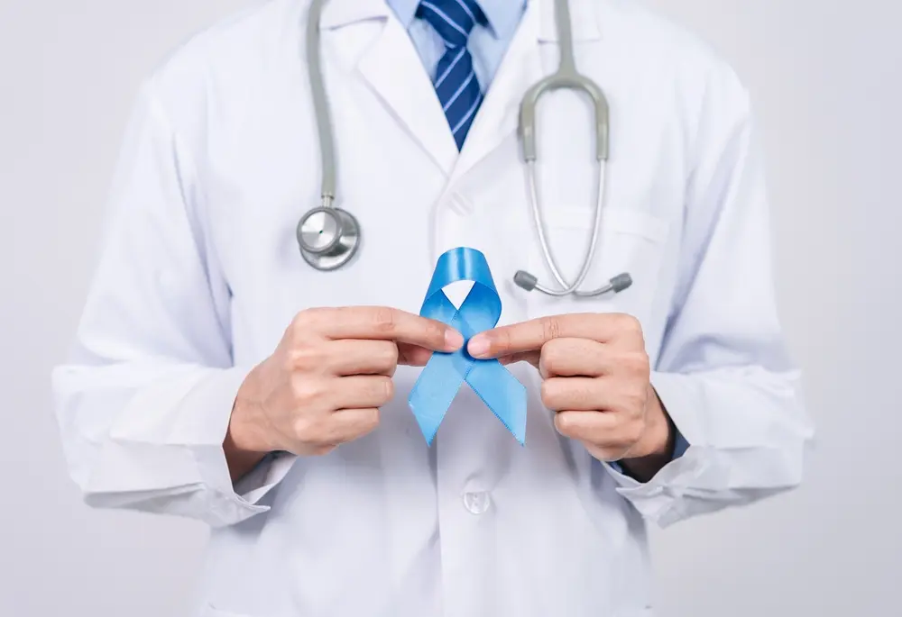 doctor holding light blue ribbon.