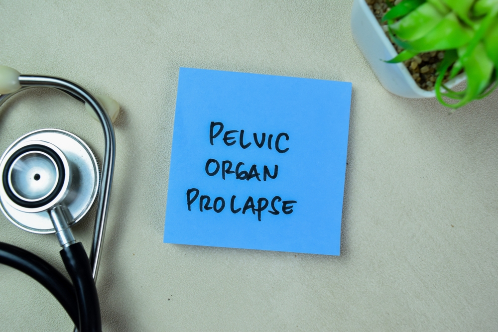 Concept of Pelvic Organ Prolapse write on sticky notes with stethoscope isolated on Wooden Table.